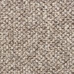Close-up of beige looped carpet fibers showing a textured, woven surface